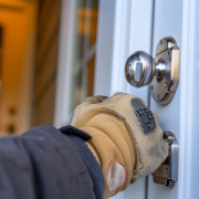 Door Lock Snapping Protection Gloved hand testing door lock cylinder, illustrating lock snapping risk and home security